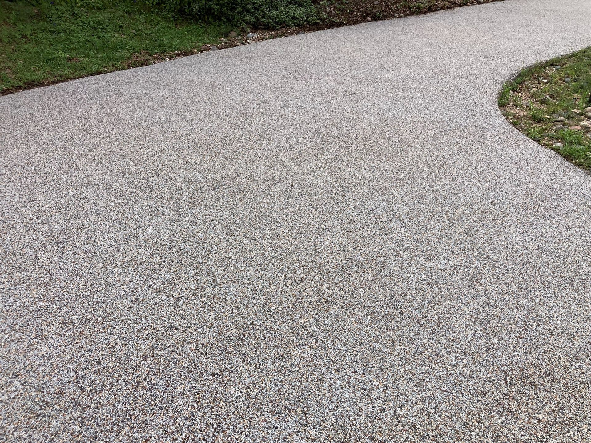 A gray speckled rubber stone driveway.